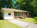 Inviting front yard featuring a well-manicured lawn, a concrete driveway, and a glimpse of the home's appealing exterior at 7125 Chappell Cir, Atlanta, GA 30360