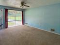Bright living room featuring neutral carpet, a ceiling fan, and a large slider that provides ample natural light and outdoor views at 7125 Chappell Cir, Atlanta, GA 30360