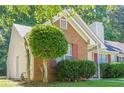 Close up of a charming single story home with brick and vinyl siding, manicured lawn, and mature trees at 1249 Scripps Sw Ct, Marietta, GA 30008