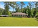 Well maintained one-story brick home with a spacious, green front lawn and mature trees at 2320 Tilson Cir, Decatur, GA 30032