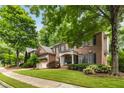 Beautiful two-story brick home featuring a manicured lawn and lush trees at 3227 Collier Gate Se Ct, Smyrna, GA 30080