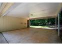 Spacious carport area featuring concrete flooring, exposed beams, and a side door entrance at 5340 Young Deer Dr, Cumming, GA 30041