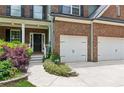 Close up on this home featuring a two-car garage and landscaped front yard at 5655 Stevehaven Ln, Cumming, GA 30028