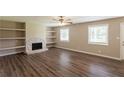 Inviting living room featuring a stone fireplace, built-in shelves, and hardwood floors at 225 Fireside Way, Fairburn, GA 30213