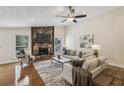 Bright living room featuring a stone fireplace, ceiling fan, and elegant decor, creating a cozy atmosphere at 255 Broken Lance Pl, Johns Creek, GA 30022