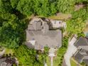 Aerial view of home with rear patio, stone details, and professional landscaping at 8470 Lazy Oaks Ct, Atlanta, GA 30350