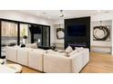 Modern living room with cozy fireplace, marble wall, and a stylish sectional sofa at 185 Pebble Trl, Alpharetta, GA 30009