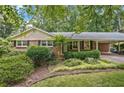 Inviting brick home with black shutters and mature landscaping exudes classic charm and curb appeal at 3327 Spring Meadow Ct, Tucker, GA 30084