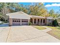 A long driveway leading to a brick home with a 2-car garage and an arched brick porch at 6418 Briarwood Ct, Riverdale, GA 30296