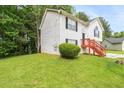 Side view of a two-story home featuring green grass, a neat bush, and red stairs at 2240 Creekside Vw, Decatur, GA 30035