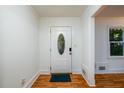 Bright entryway featuring wood floors, white trim, and a front door with decorative glass window at 4324 Japonica Sw Ct, Lilburn, GA 30047