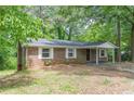 Brick home with white shutters and covered entrance offering a blend of classic design and outdoor charm at 143 Longview Rd, Fayetteville, GA 30214