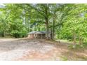 Inviting single-story brick home with a covered porch and large front yard surrounded by lush trees at 143 Longview Rd, Fayetteville, GA 30214