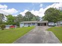 Traditional home with a long driveway, mature trees, a carport, and a well-maintained lawn at 4002 Phylis Pl, Decatur, GA 30035