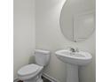 Stylish pedestal sink and toilet in a modern, well-lit powder room at 119 Champions Blvd., Dallas, GA 30157