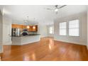 Open-concept living room and kitchen featuring hardwood floors, stainless appliances, and great natural light at 3621 Vinings Slope Se # 3510, Atlanta, GA 30339