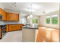 Open-concept living space featuring hardwood floors, island kitchen, and multiple windows providing natural light at 3621 Vinings Slope Se # 3510, Atlanta, GA 30339