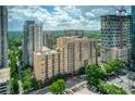 An urban high-rise condominium building with greenery and an open parking lot; construction visible in the background at 1101 Juniper Ne St # 632, Atlanta, GA 30309