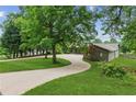Landscaped front yard with mature trees and an extra-long asphalt driveway at 2055 Cactus Ln, Cumming, GA 30040
