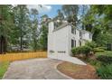 Side view showcasing attached three-car garage and expansive driveway of the white brick home at 2745 Saxon Drive, Duluth, GA 30096