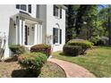 Close up of white brick home featuring decorative shrubbery and a welcoming walkway at 2745 Saxon Drive, Duluth, GA 30096
