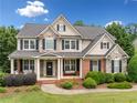 Beautiful two-story home with a stone and siding exterior, well-manicured landscaping and inviting front porch at 4715 Northridge Dr, Cumming, GA 30040