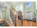 Grand foyer with hardwood floors, soaring ceilings, staircase with wood and iron railing, and arched doorway at 4715 Northridge Dr, Cumming, GA 30040