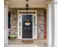 Inviting front entry with stone accents, black door, and a warm 