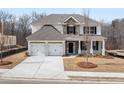 New two-story home with white brick, stone accents, and a two-car garage on a meticulously landscaped lot at 7169 Linden Dr, South Fulton, GA 30349