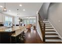 Open-concept kitchen with granite countertops and views into the living room and staircase at 3920 Baverton Dr, Suwanee, GA 30024