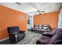Living room featuring hardwood floors, bright orange walls, and a ceiling fan at 2087 Chestnut Way, Lithia Springs, GA 30122