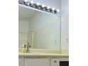 Bathroom features a large mirror, vanity with white cabinets, and tiled walls and shower at 225 Magnolia Tree Ct, Johns Creek, GA 30022