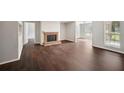 Spacious living room featuring a brick fireplace, hardwood floors, and large windows with natural light at 5555 Mountain Springs Cir, Stone Mountain, GA 30088