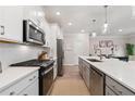 Modern kitchen featuring stainless appliances, white cabinetry, quartz counters, and stylish pendant lighting at 3610 Silvery Way, Powder Springs, GA 30127