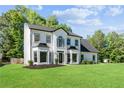 Two story white and black home featuring a lush lawn and mature trees at 4168 Arapaho Dr, Powder Springs, GA 30127