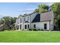 A two-story white home with black trim, landscaping, and a well-manicured lawn at 4168 Arapaho Dr, Powder Springs, GA 30127