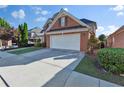 Well-maintained home featuring a long driveway leading to an attached two-car garage at 1885 Hickory Station Cir, Snellville, GA 30078