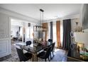 Formal dining room features a black dining table with gold accents, elegant lighting, and neutral decor at 5663 Eternal Dr, Atlanta, GA 30349
