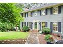 Charming two-story home featuring a symmetrical facade with beautiful lawn and manicured shrubs at 2041 Millspring Nw Way, Kennesaw, GA 30152