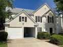 Exterior elevation with two-car garage; one door is open, and landscaped yard is visible at 2130 Chattahoochee Dr, Duluth, GA 30097
