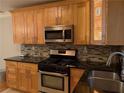 Modern kitchen featuring stainless steel appliances, granite countertops, and warm wood cabinetry at 375 6Th Ne St # 5, Atlanta, GA 30308