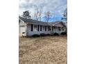 Well-maintained home with gray siding, black shutters, an attached garage, and mature trees in the background at 6540 Old White Mill Road Rd, Fairburn, GA 30213
