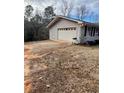 Spacious two-car garage with white doors, ample parking space, and well-maintained exterior features at 6540 Old White Mill Road Rd, Fairburn, GA 30213