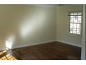Sunlit bedroom featuring gleaming hardwood floors, neutral paint, a bright window, and classic trim at 1253 Dunwoody Ne Ln, Brookhaven, GA 30319