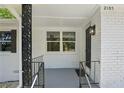 Close up of the front porch featuring decorative metal columns, a white painted brick wall, and a black front door at 2105 Royal Fox Way, Decatur, GA 30032
