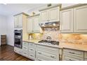 Well-lit kitchen featuring custom cabinets, granite countertops, and stainless steel appliances at 238 Trecastle Sq, Canton, GA 30114