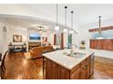 Open-concept design with hardwood floors connecting the kitchen island and cozy living area at 238 Trecastle Sq, Canton, GA 30114