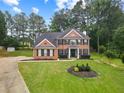 Beautiful two-story brick home with a well-manicured lawn and ample greenery at 9307 Glenleigh Way, Jonesboro, GA 30236