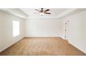Spacious bedroom with plush carpet, a ceiling fan, and tray ceilings at 181 Dewy Rd # 70, Lilburn, GA 30047