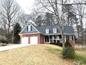 Traditional brick home featuring a two-car garage, welcoming front porch, and well-maintained landscaping at 6745 Fairfield Trce, Suwanee, GA 30024